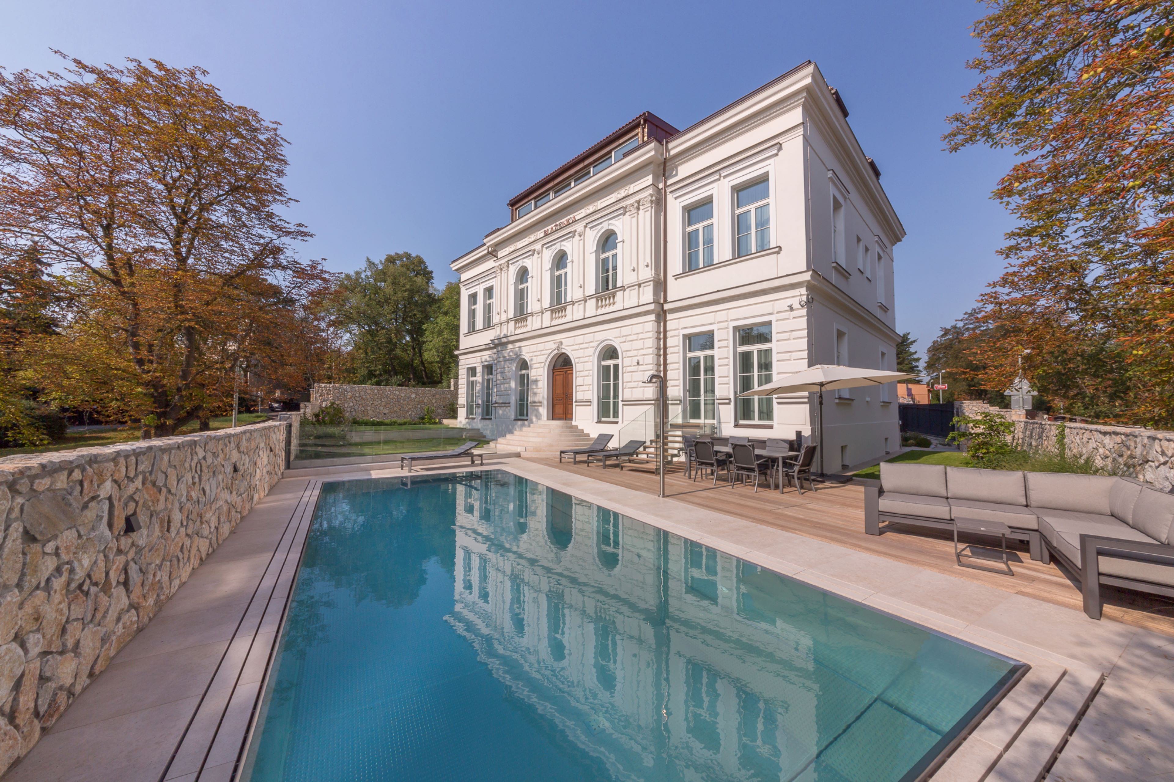 Outdoor Pool with Hidden Overflow Under Stone Panelling | IMAGINOX GROUP