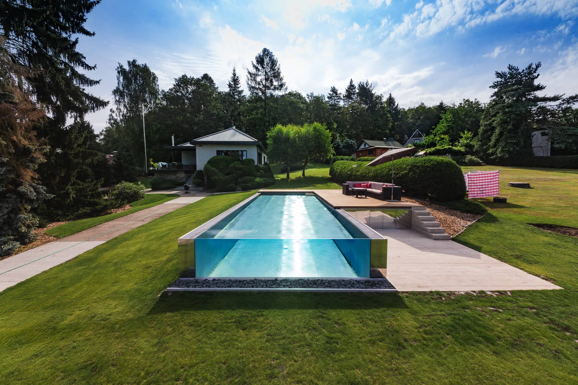 Stainless-Steel Swimming Pool with Overflow Above a Glass Partition